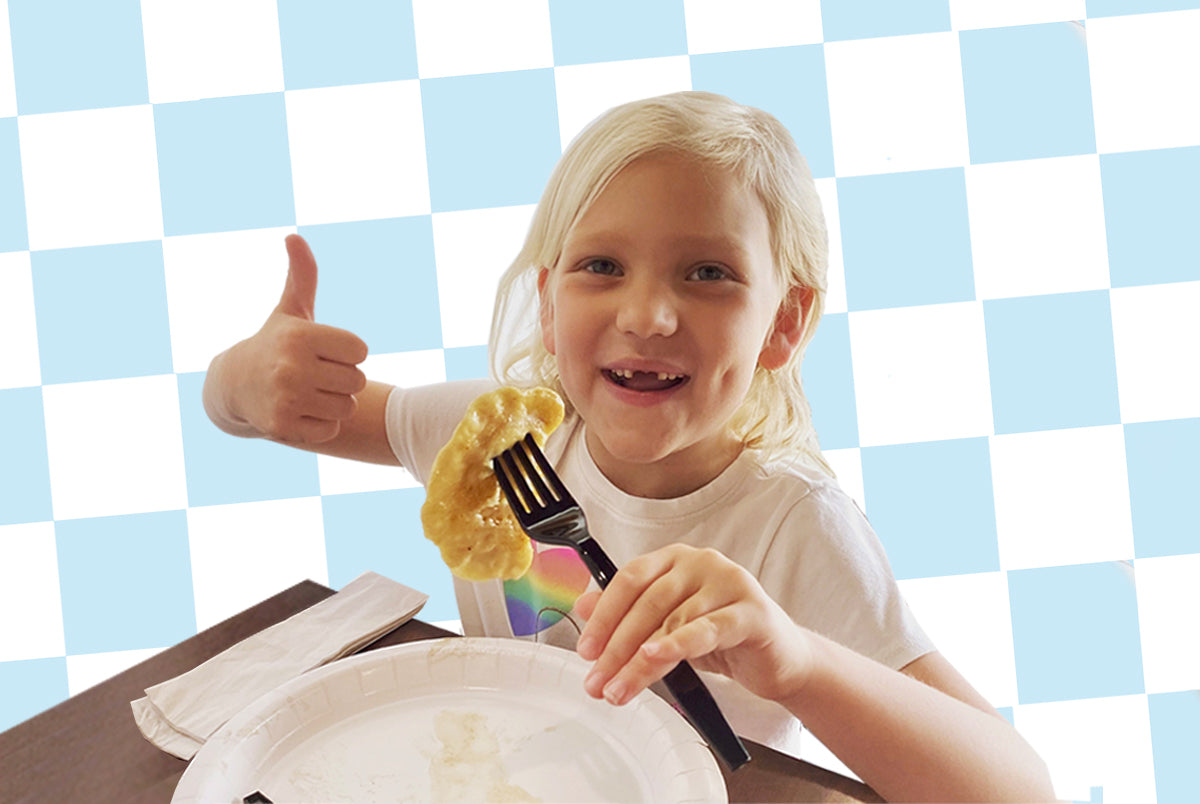 Child giving a thumbs up to Pierogi Bros pierogi with a fork and plate against a checkered background